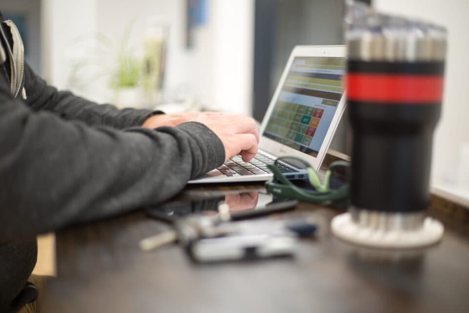 Hands typing at a laptop on a digitization workstation