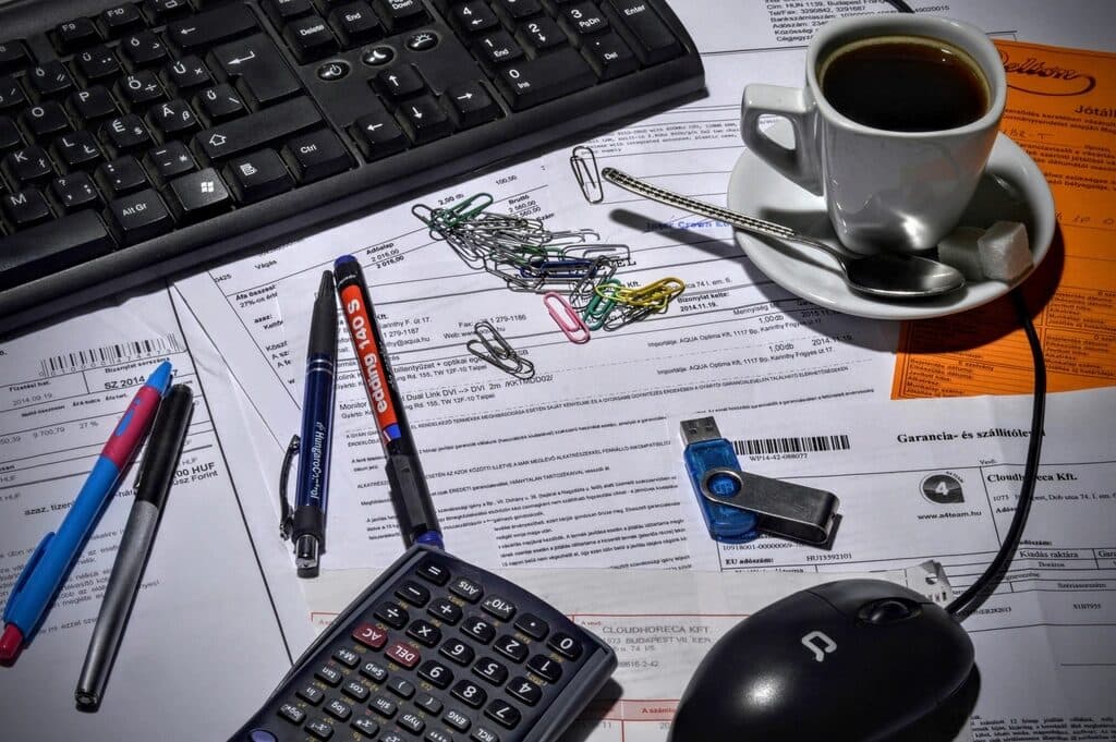 A records officer's desk with documents, calculator and storage media