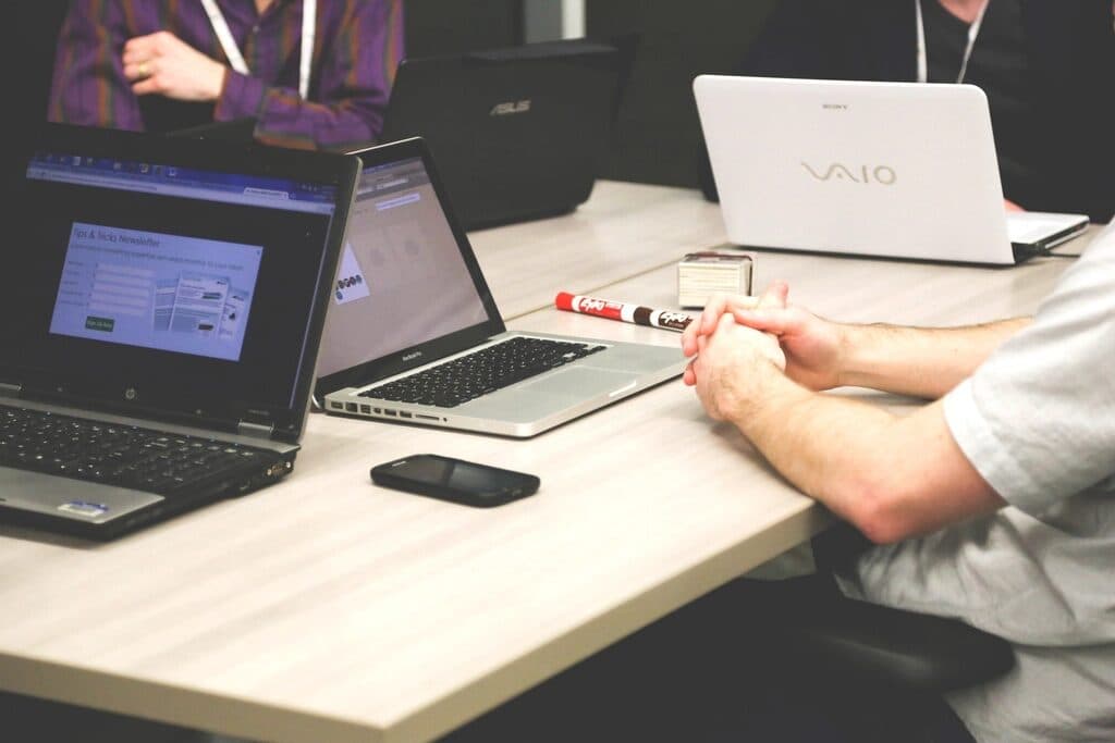 A team reviewing records together on laptops